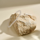 Clear bracelet on a textured stone surface with a neutral background