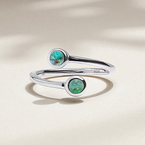 Silver ring with turquoise stones on a beige background