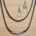 Necklace with black rope chain and silver clasp on a wooden surface