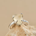 Silver ring with a Libyan Desert Glass stone on a beige rock